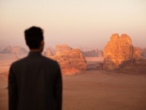 a man standing in front of a desert landscape